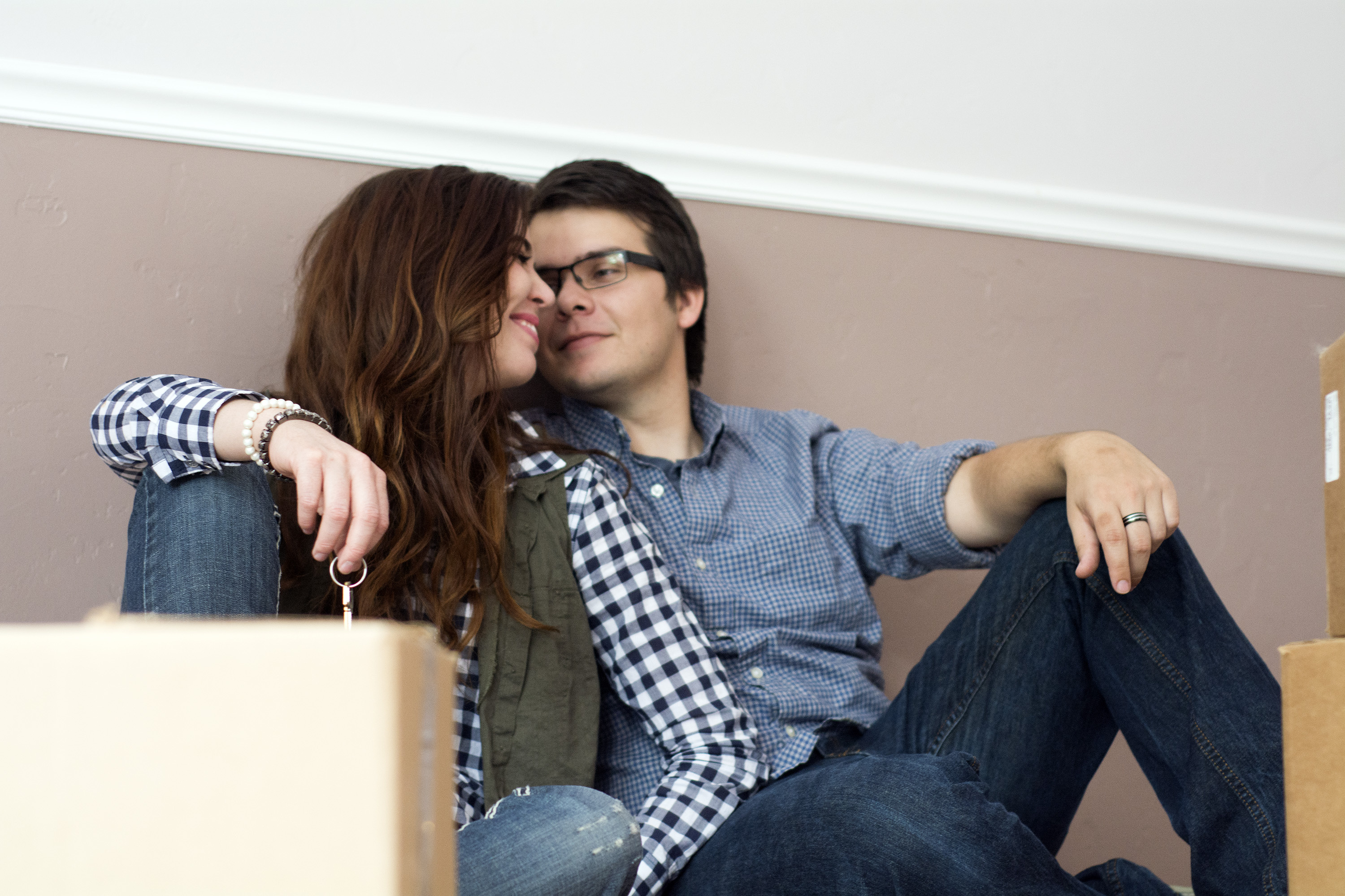 couple in new home holding keys in front of new boxes